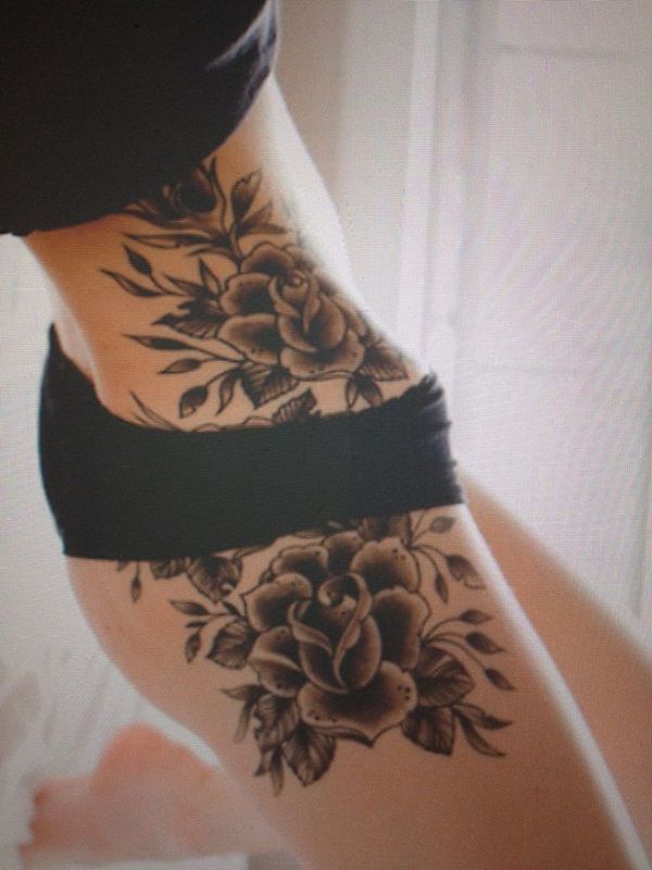 Dark rose tattoo on lower rib and hip